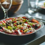 Enticing Mediterranean salad featuring olives, cheese, and fresh vegetables on a ceramic plate.