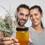 man and woman holding plants